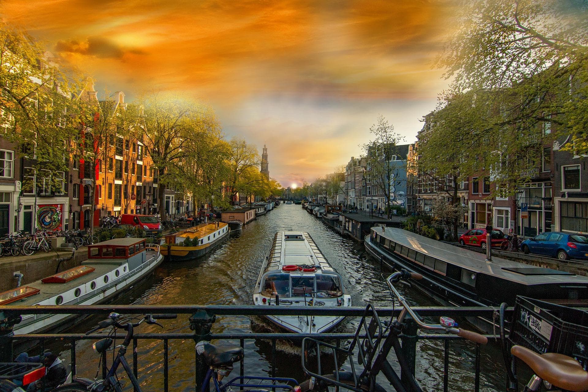 Amsterdam: Kanál s loděmi a domy. Město tulipánů a dřeváků za soumraku.