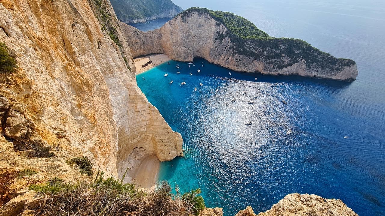 Zakynthos: Pláž Navagio. Tyrkysové moře, útesy a lodě. Dovolená v Řecku.