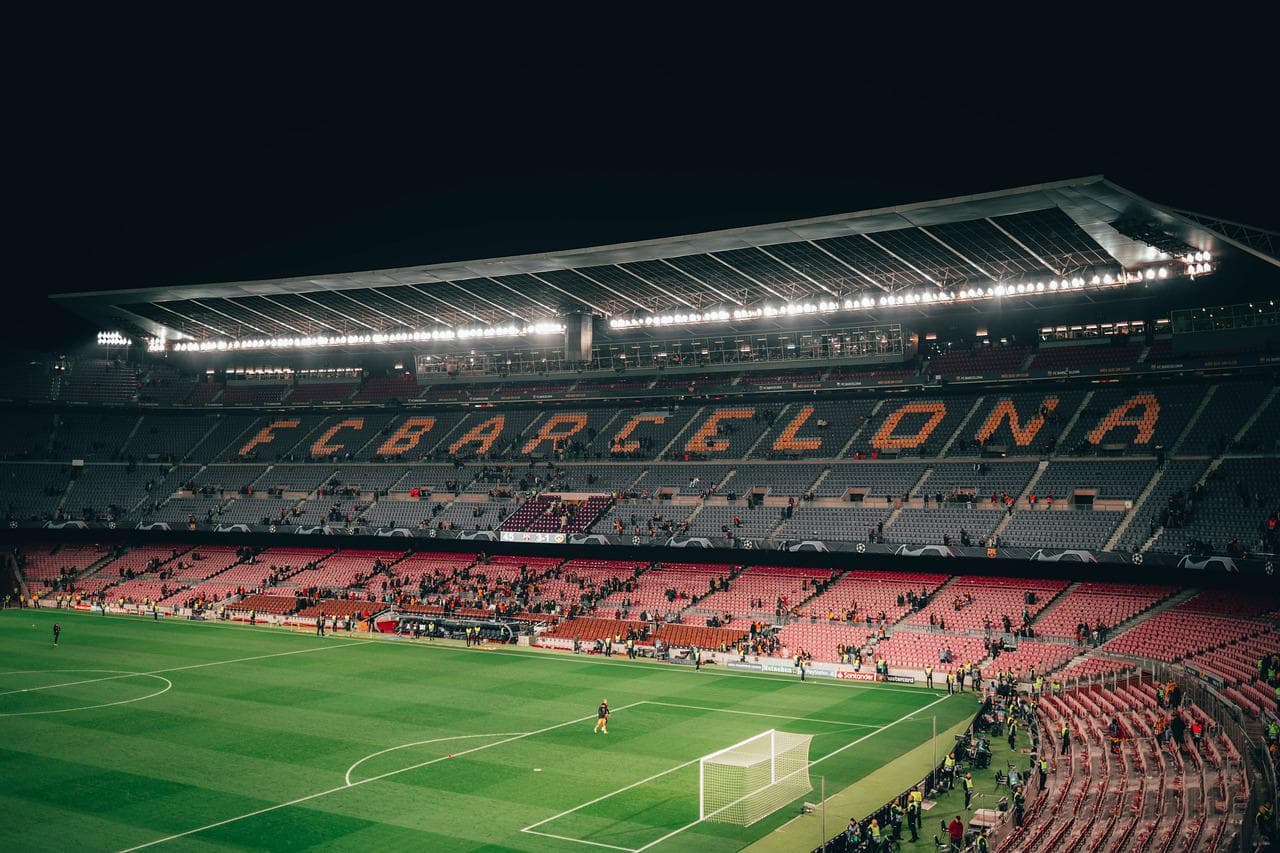 Fotbalový stadion FC Barcelona. Pohled na hřiště a tribuny s nápisem FC Barcelona.