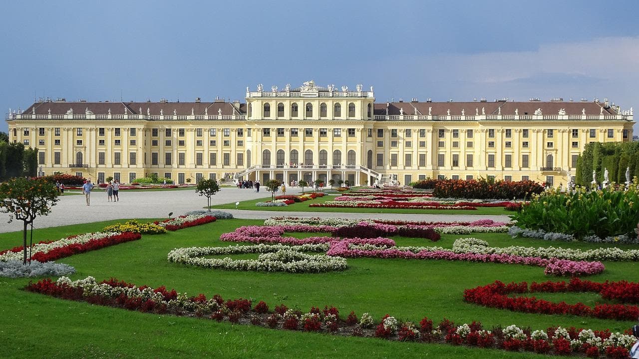 Schönbrunn Vídeň: Barokní palác s květinovými záhony a zelení. Krásná architektura.