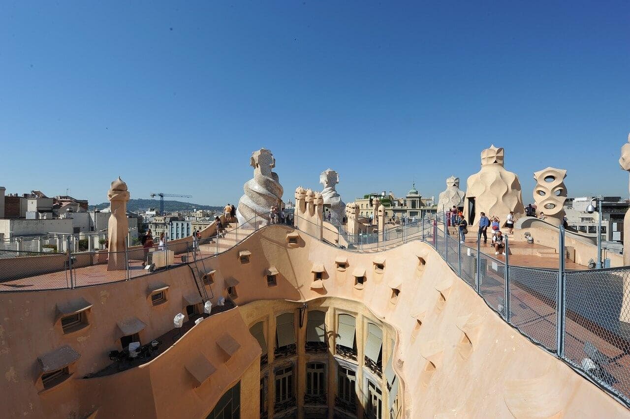 Střecha Casa Milà, Barcelona. Gaudího architektura, komíny a panorama města.