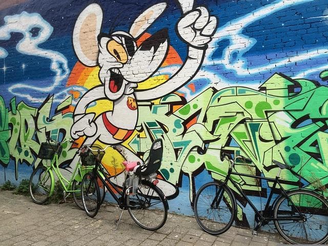 Graffiti s Myšákem Mickeym a jízdní kola. Umění na zdi, městská scéna.