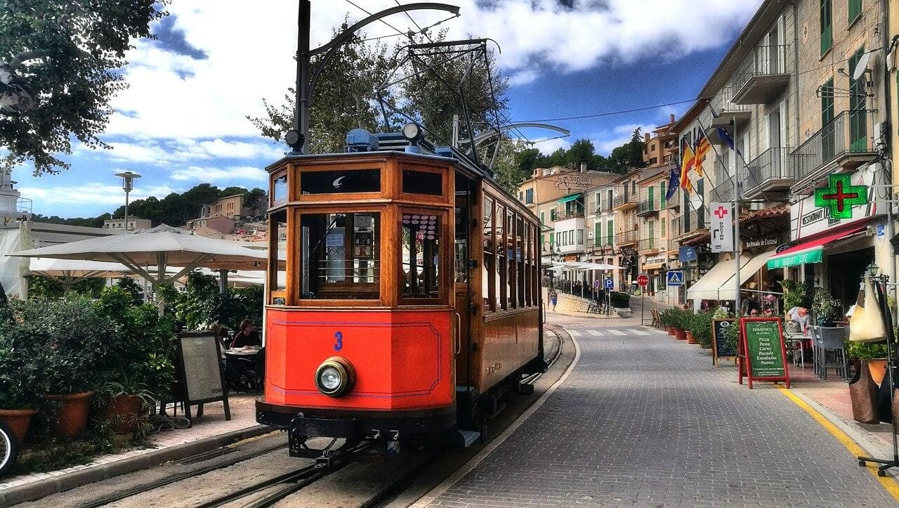 Retro tramvaj v Sólleru, Mallorca. Ulice s kavárnami a obchody. Turistická atrakce, cestování.