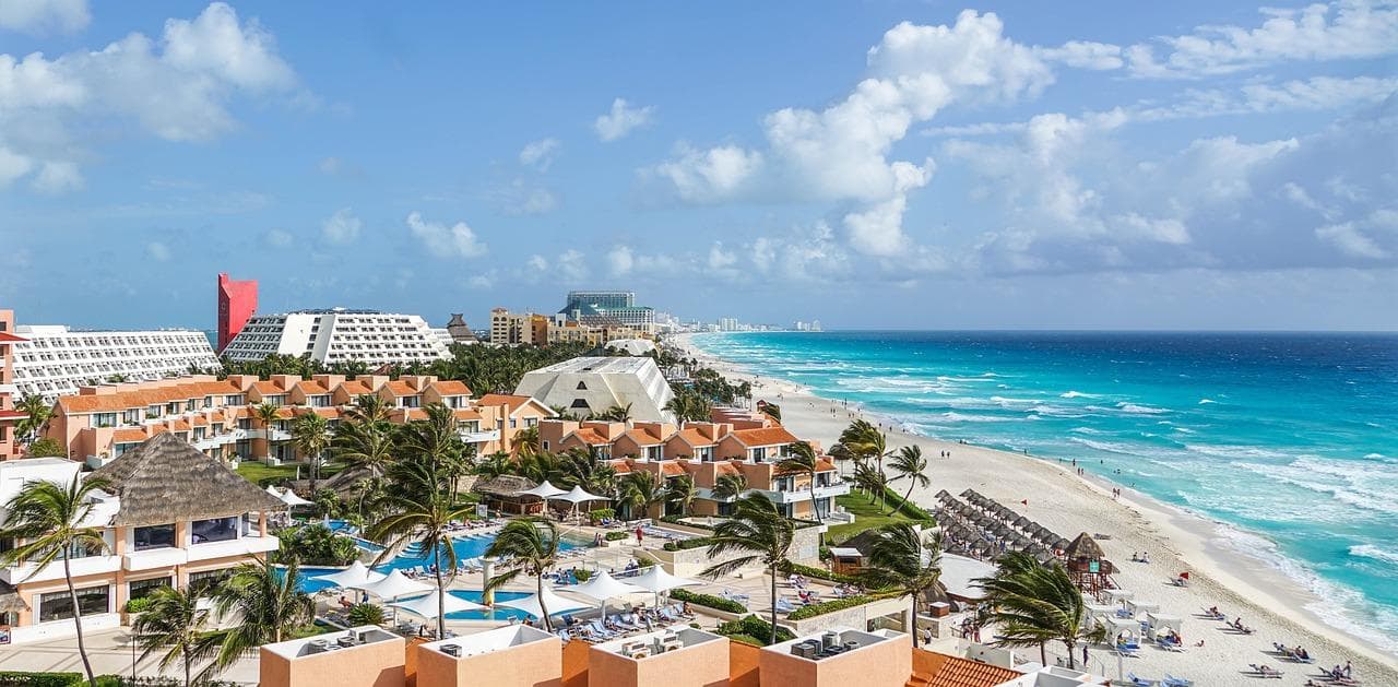 Letenky do Cancúnu: Pohled na pláž, hotely a tyrkysové moře v mexickém Cancúnu. Dovolená snů.