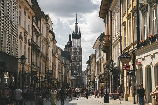Krakov, Polsko. Mariánská bazilika a ulice s lidmi. Turistická destinace, architektura města.