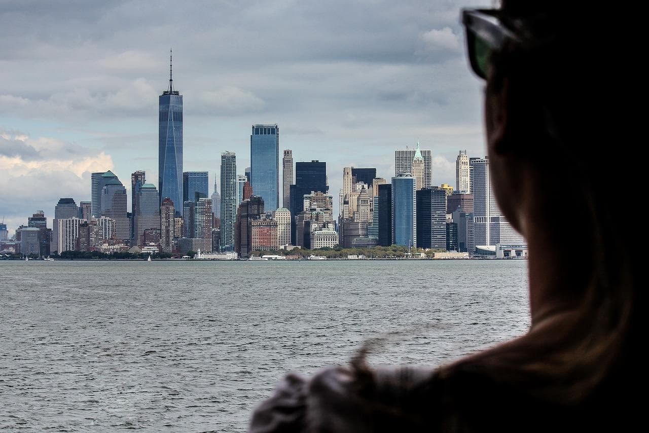 Levné cestování: Panorama New Yorku. Mrakodrapy a silueta ženy.