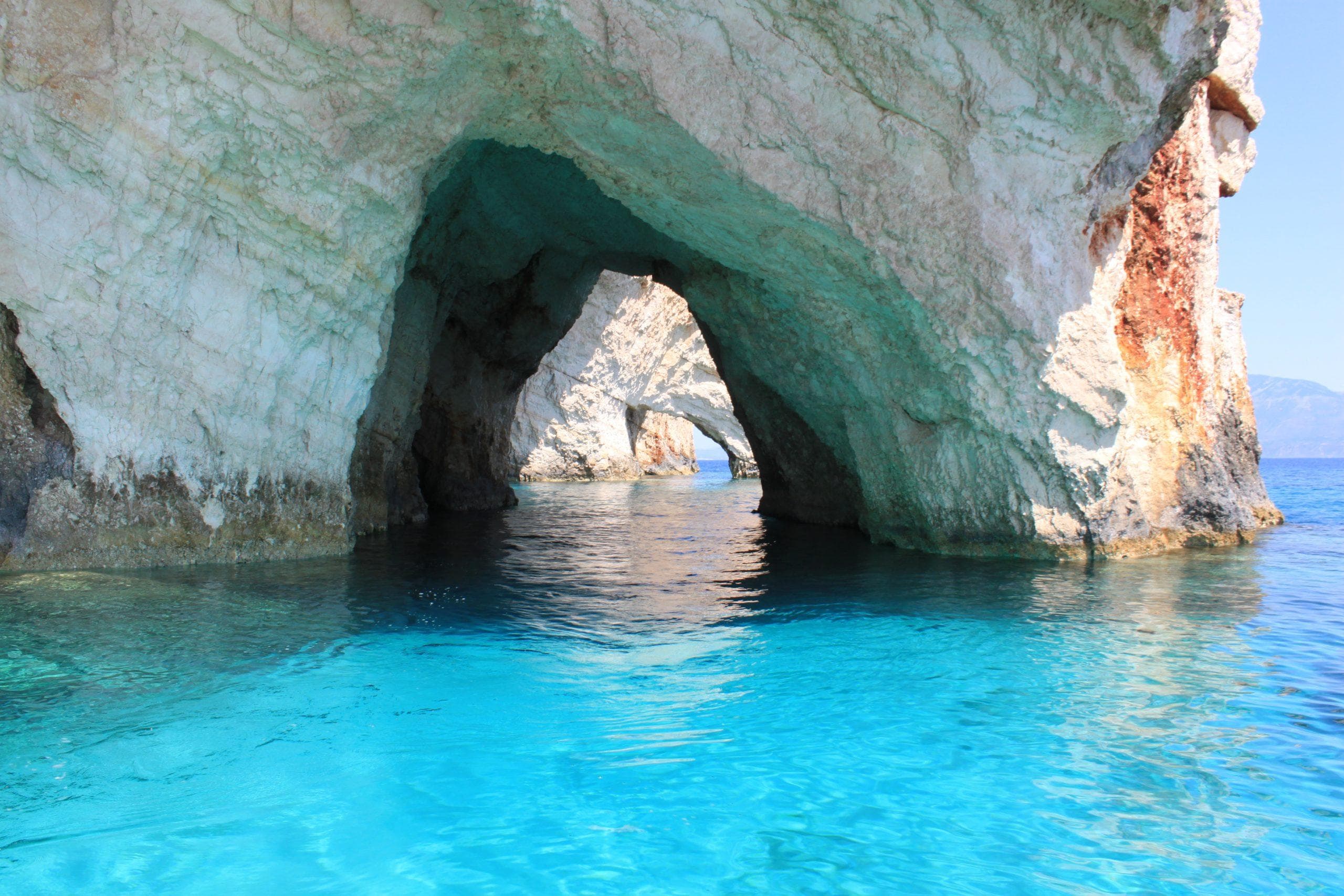 Modré jeskyně Zakynthos. Tyrkysová voda a bílé skalní útvary.