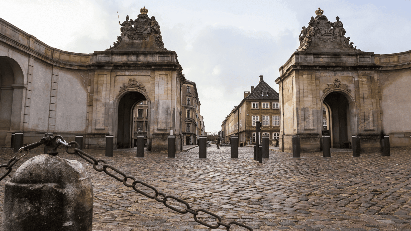 Kodaň, Dánsko: Pohled na bránu s kamennou dlažbou a historické budovy. Architektura města.