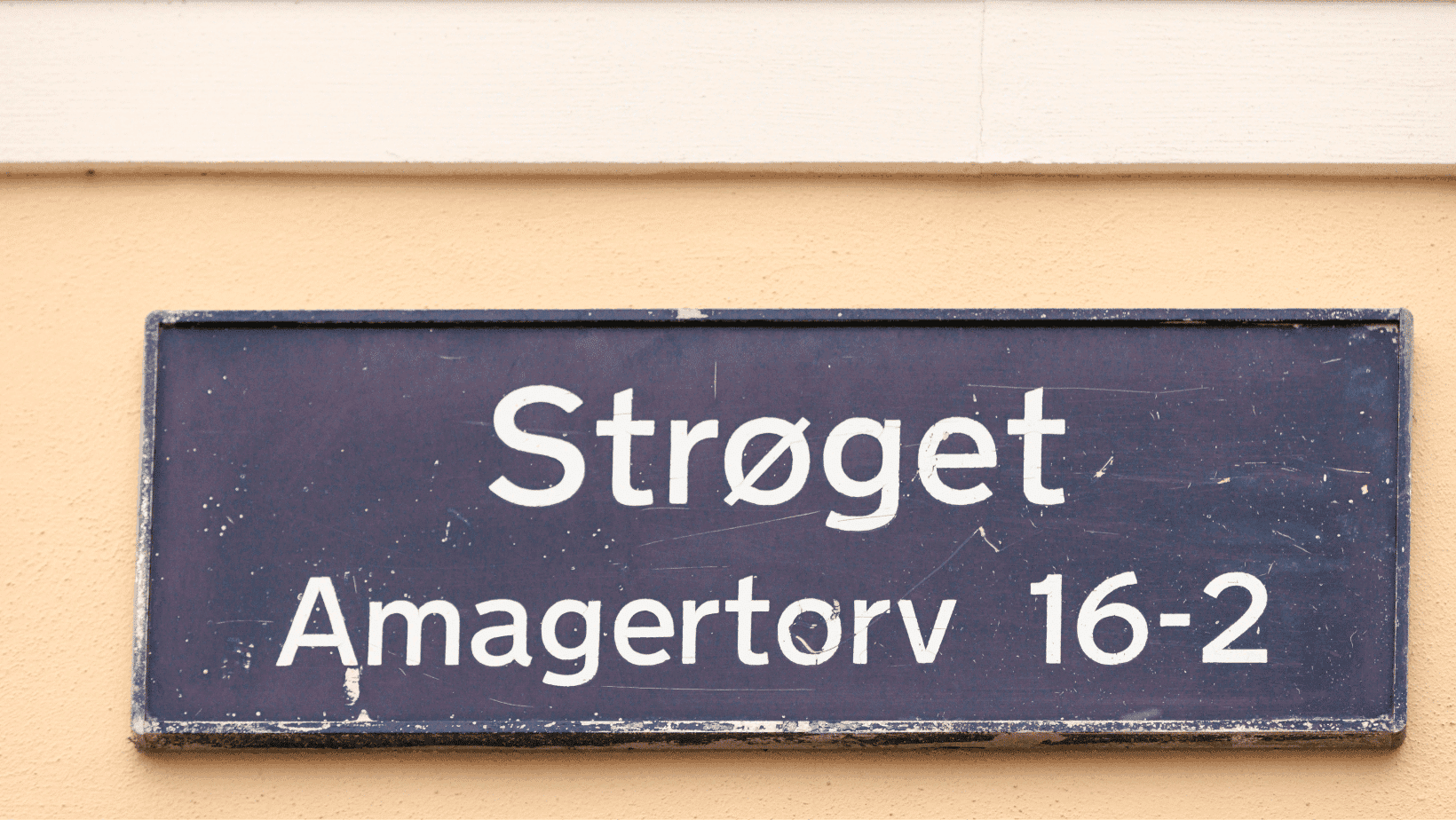 Ulice Strøget, ráj nákupů v Kodani. Cedule s názvem ulice a adresou Amagertorv 16-2.