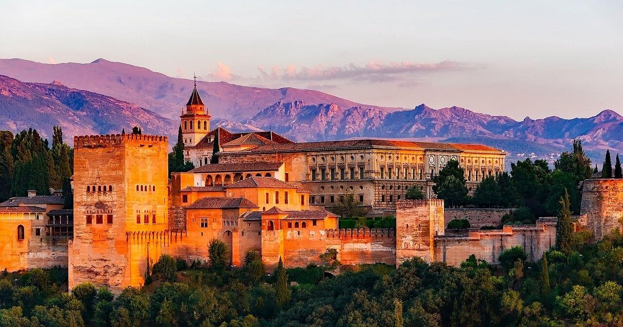 Město Granada: Alhambra, historický palác a pevnost s horami v pozadí. Krásná architektura.