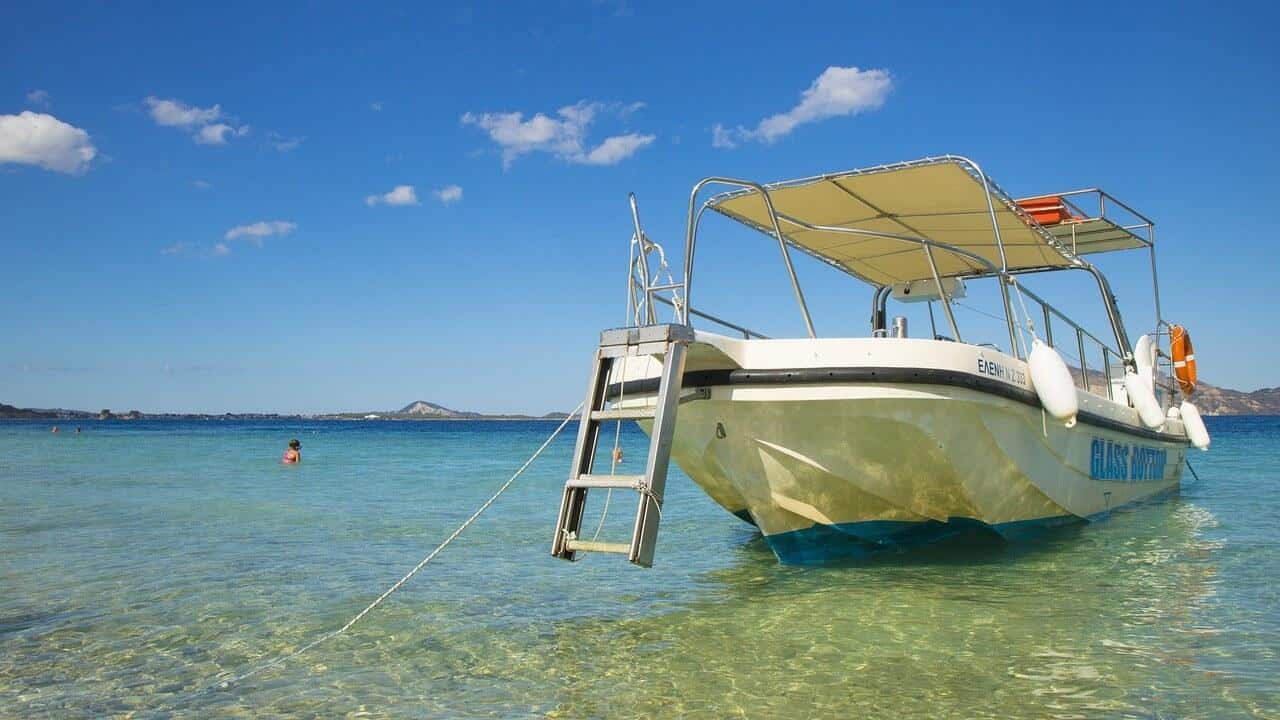 Loď na pláži Banana, Zakynthos. Průzračná voda, modrá obloha. Dovolená v Řecku.