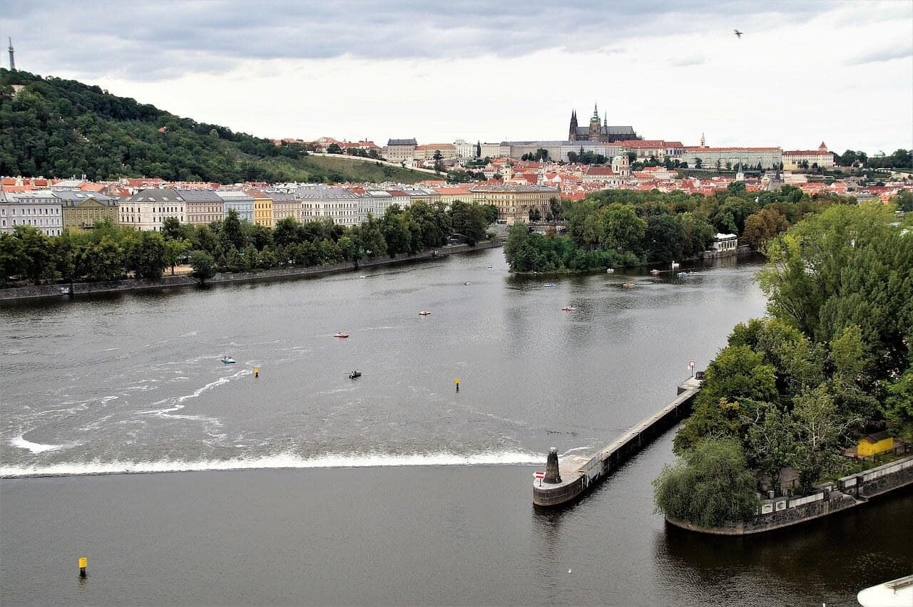 Libeňský ostrov, Praha. Vltava s majákem, Pražský hrad v pozadí. Pohled na panorama Prahy.