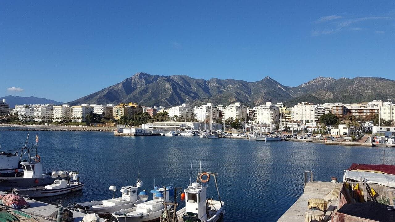 Costa del Sol: Přístav s loděmi, město a hory. Místo věčného slunce, dovolená ve Španělsku.