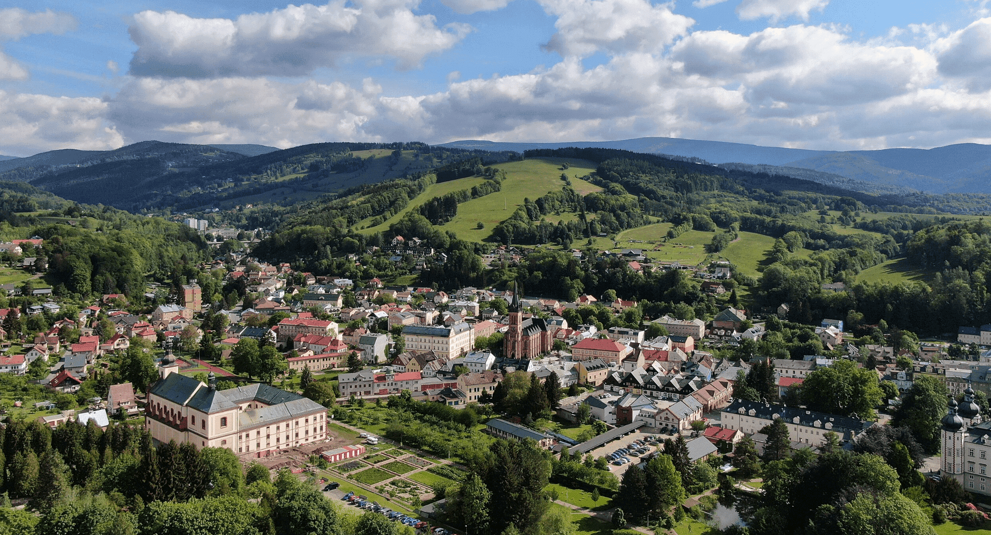 Vrchlabí: panorama města s architekturou, Krkonoše v pozadí. Přírodní poklady a historie.