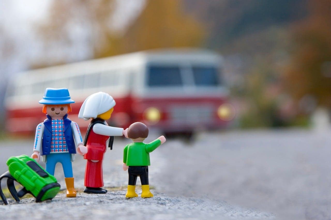 Rodina Playmobil čeká na autobus na cestách po Evropě. Děti s tabletem objevují svět, vzdělávání a zábava v jednom.