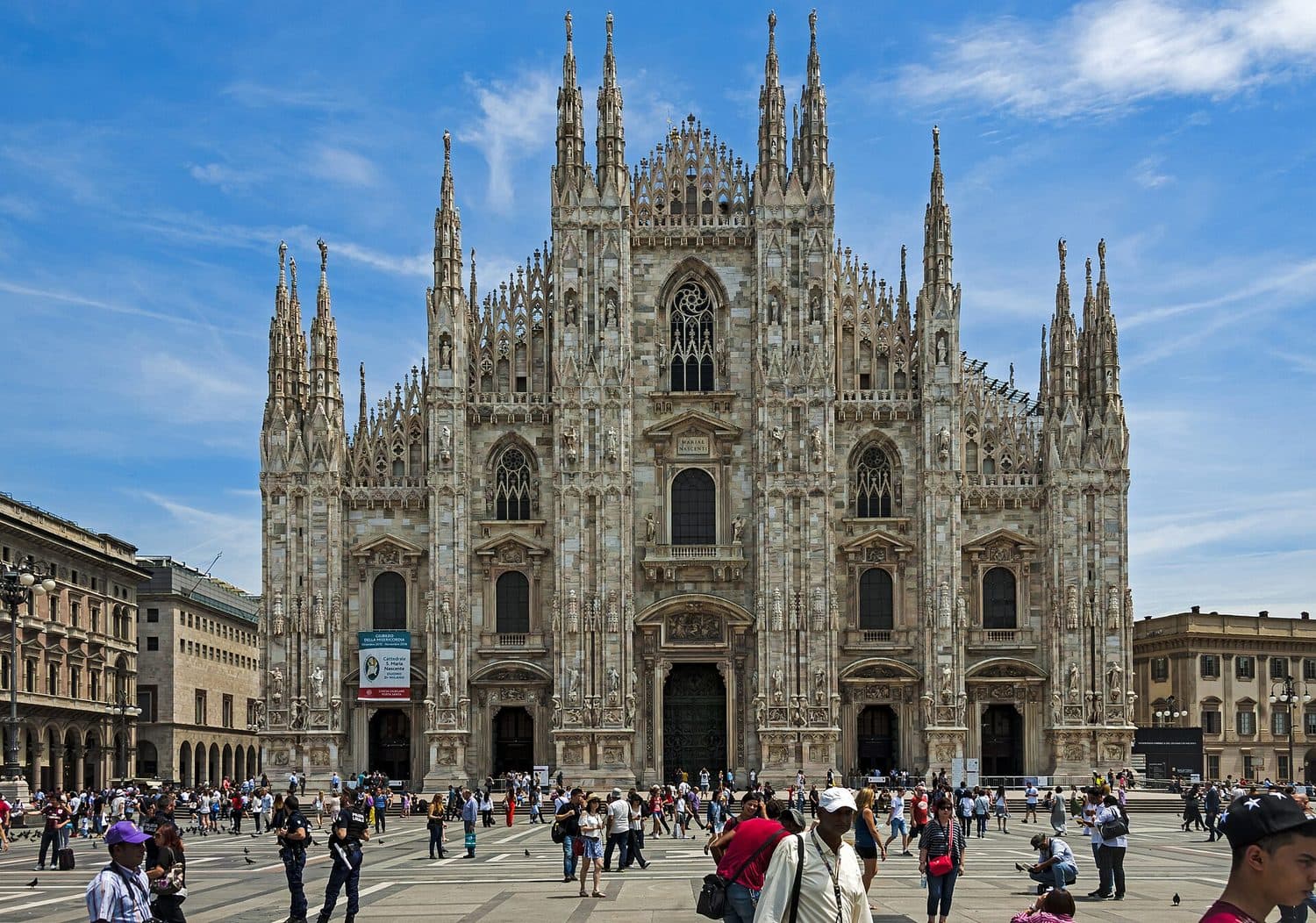Průčelí katedrály Duomo v Miláně s turisty na náměstí Piazza del Duomo