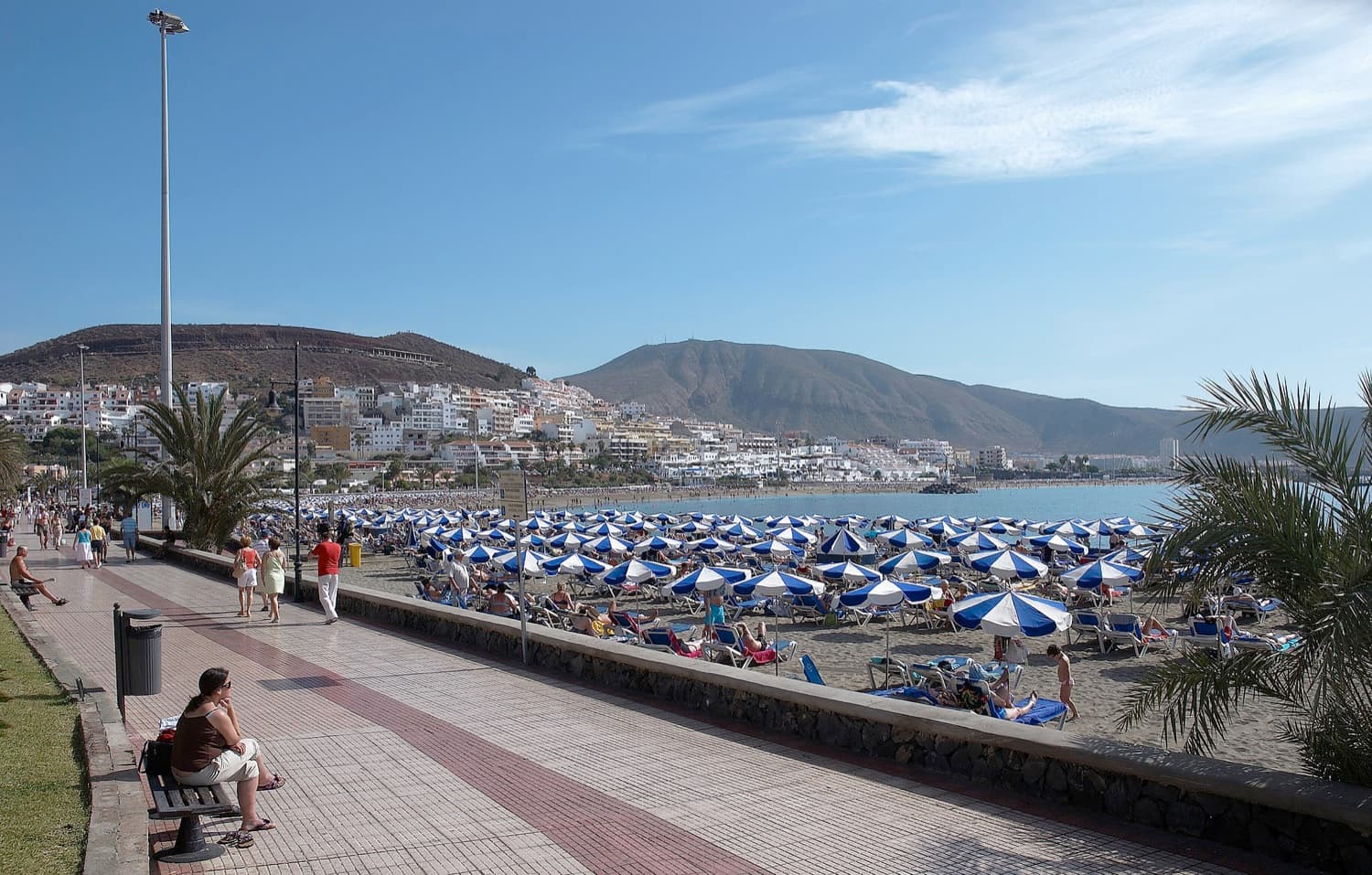 Pláž a promenáda v Los Cristianos na jihu Tenerife se slunečníky