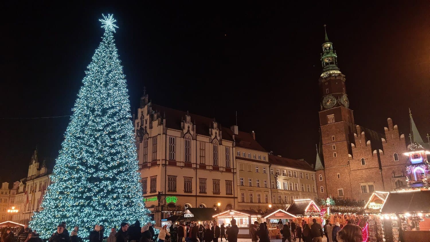 Vánoční strom a radnice na Rynku ve Vratislavi večer, kolem stánky vánočního trhu