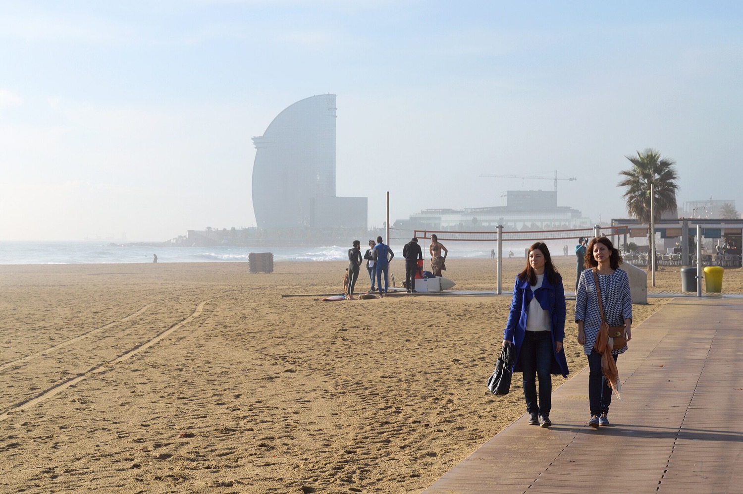 Ranní procházka po pláži Barceloneta v Barceloně s hotelem W v oparu