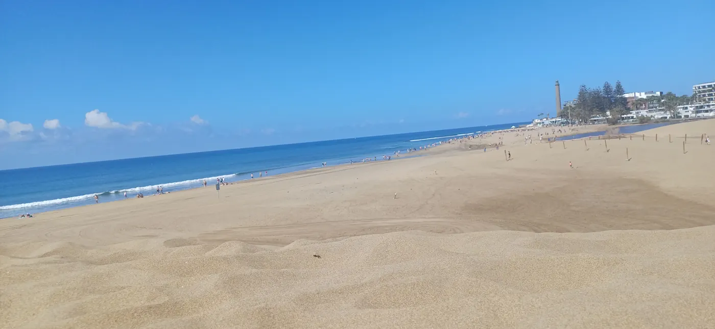 Pláž Maspalomas s majákem a hotely na obzoru
