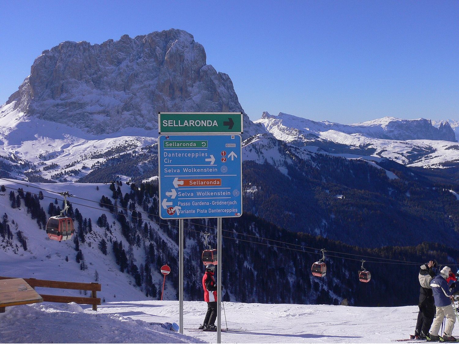 Rozcestník Sellaronda na sjezdovce, v pozadí Sassolungo
