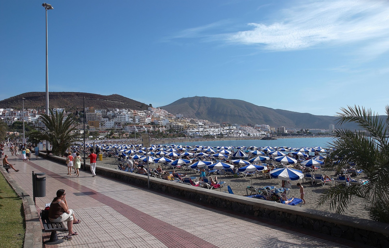 Pláž a promenáda v Los Cristianos na jihu Tenerife se slunečníky