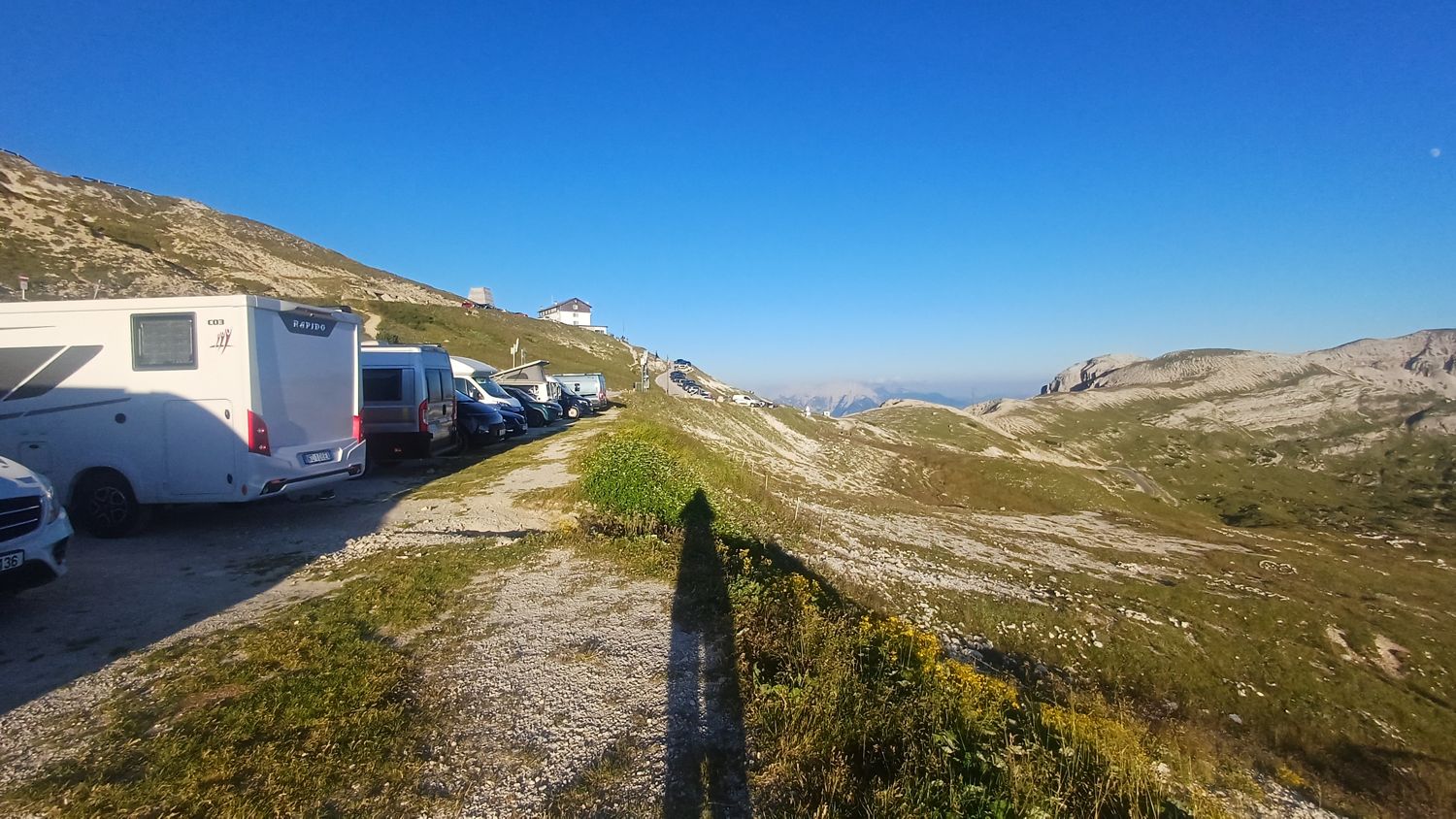 Obytné vozy zaparkované podél cesty u parkoviště Tre Cime