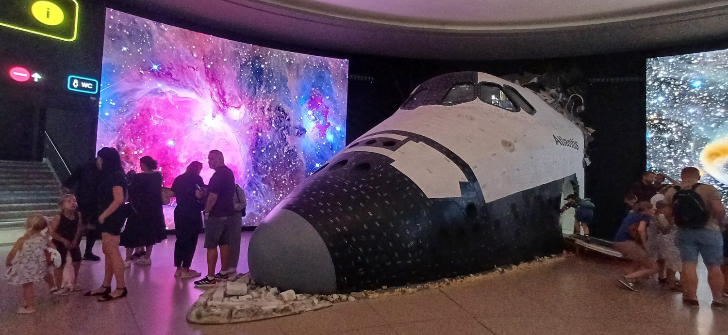 Foyer Planetária Praha s modelem raketoplánu Atlantis před LED stěnami s mlhovinou