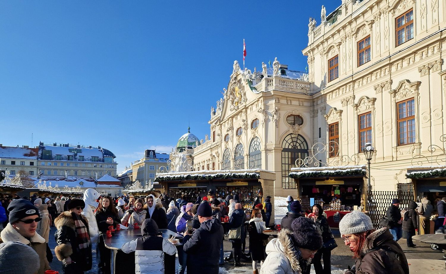 Stánky vánočního trhu před Horním Belvederem ve Vídni za slunečného zimního dne